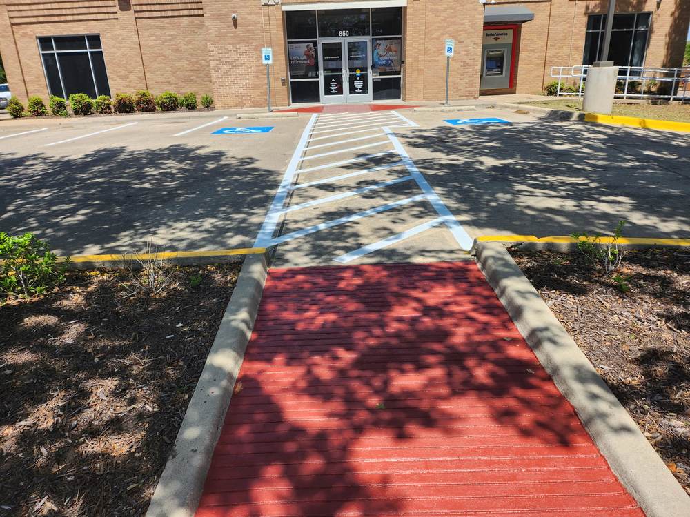 ADA accessible ramp, crosswalk and van-accessible stalls striped at a Bank of America branch