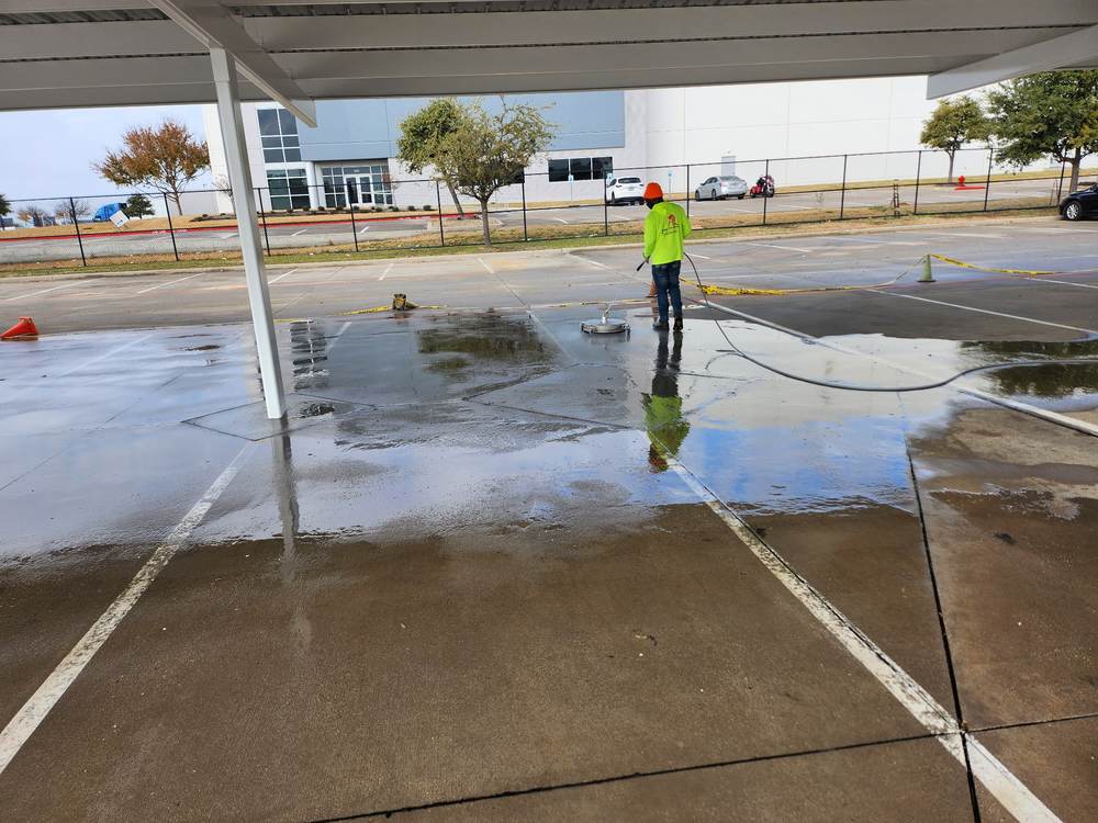 Pressure washing a commercial parking lot under a covered walkway