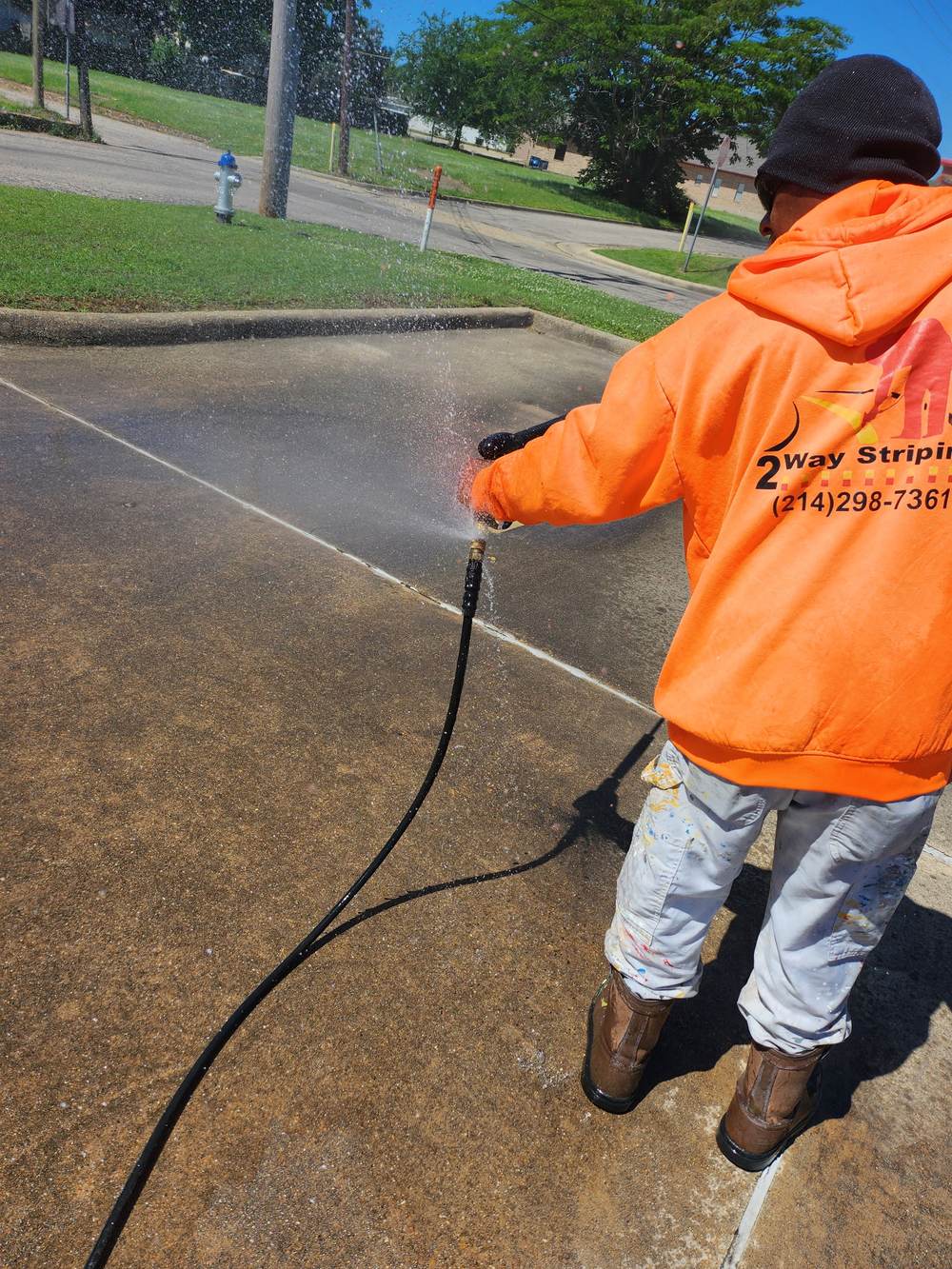 2 Way Striping crew member pressure washing a sidewalk
