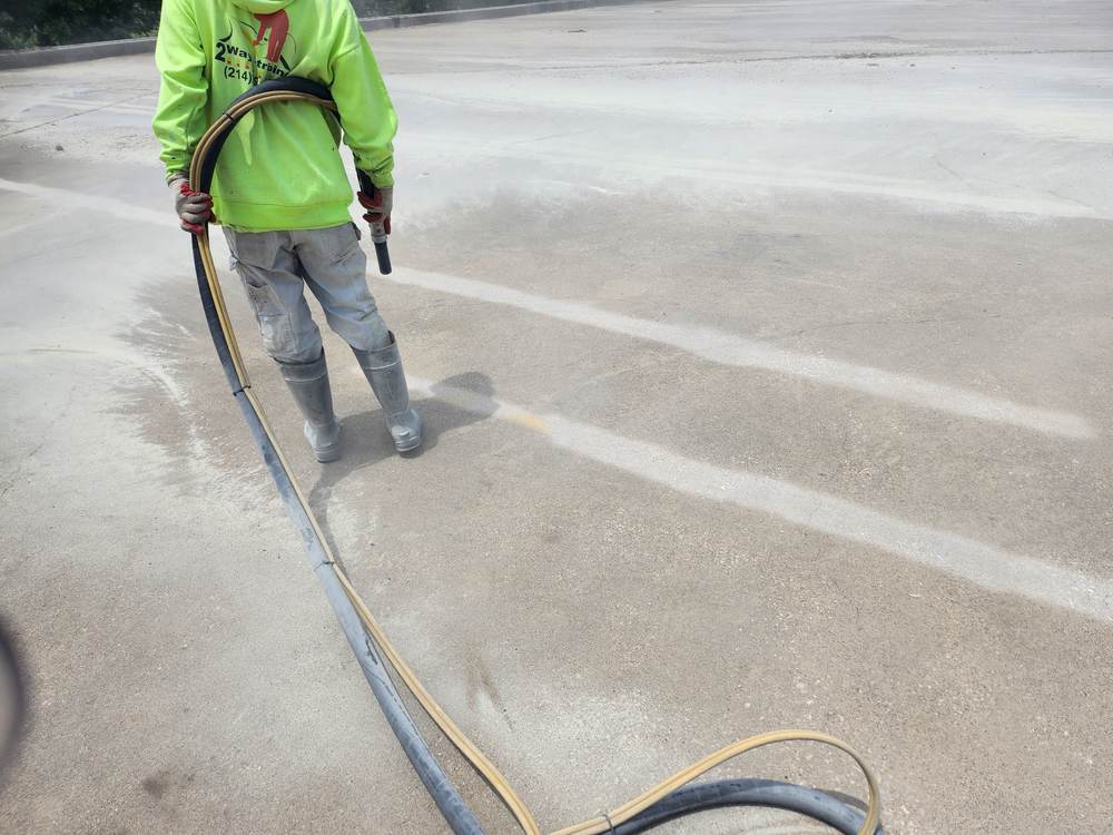 Sandblasting concrete surface prep, crew member with equipment